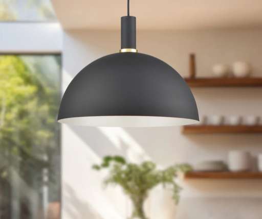 Black pendant light with gold trim hanging in kitchen