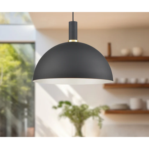 Black pendant light with gold trim hanging in kitchen