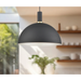 Black pendant light with gold trim hanging in kitchen