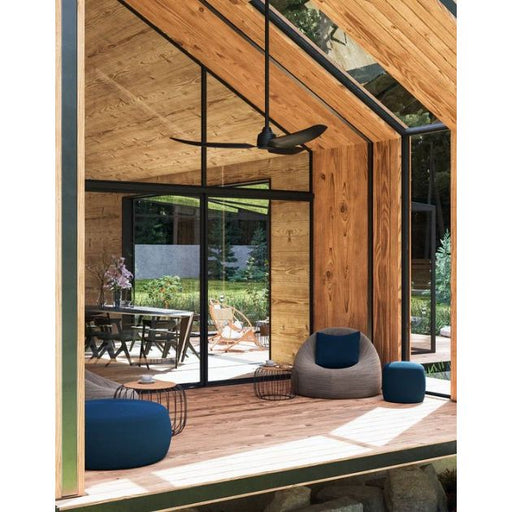 Modern indoor-outdoor living space with wooden walls, glass doors, and outdoor ceiling fan.