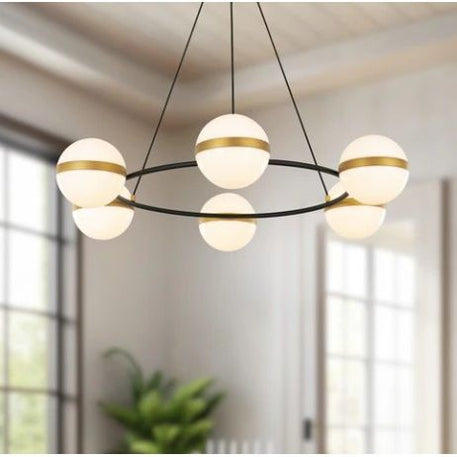 Modern chandelier with glass globe lights in a room with large windows.