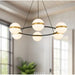 Modern chandelier with glass globe lights in a room with large windows.