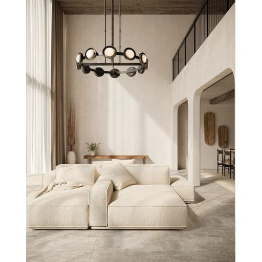 Modern living room with a chandelier, sofa, and decorative elements.