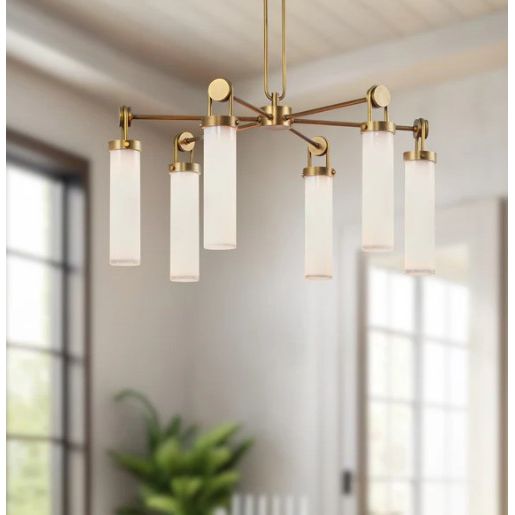 Modern chandelier with gold fixtures and white glass shades in a room with large windows.