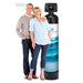 Man and woman standing next to a water filtration system on a white background