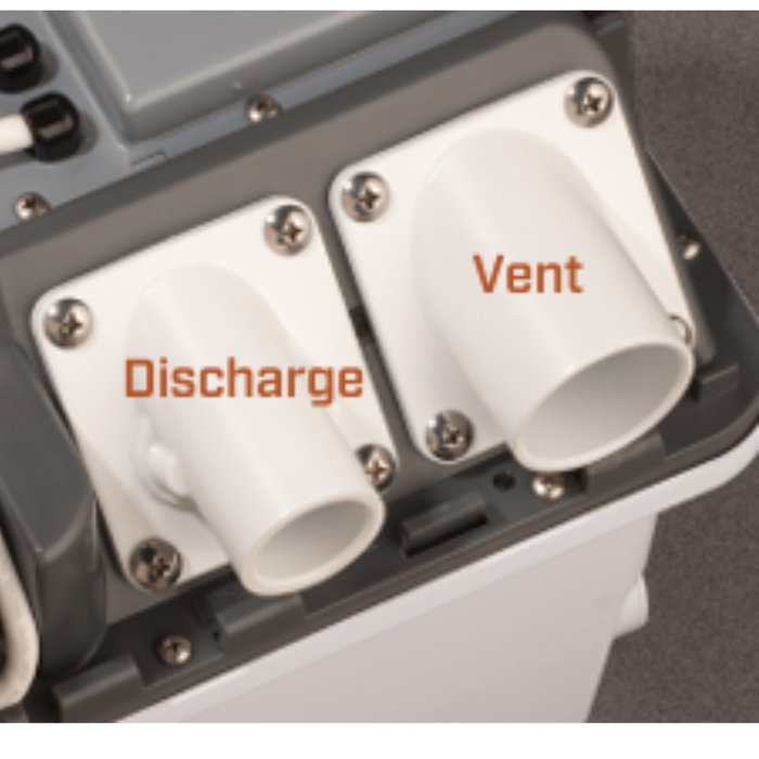 Close-up of a device with 'Discharge' and 'Vent' labels on white pipes.